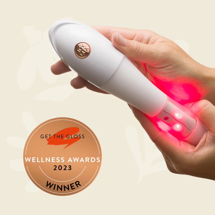 Female hands hold the Issviva x Joylux Rejuvenation device, showing its elegant and ergonomic design on a neutral background.