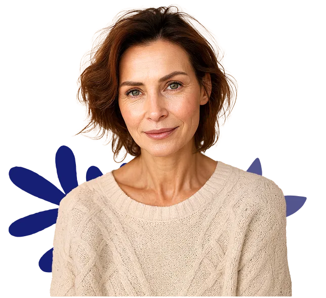 Woman wearing a beige sweater with a blue flower design on a white