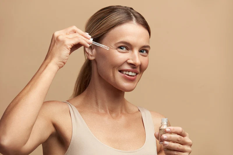 Woman applying face cream for skincare.