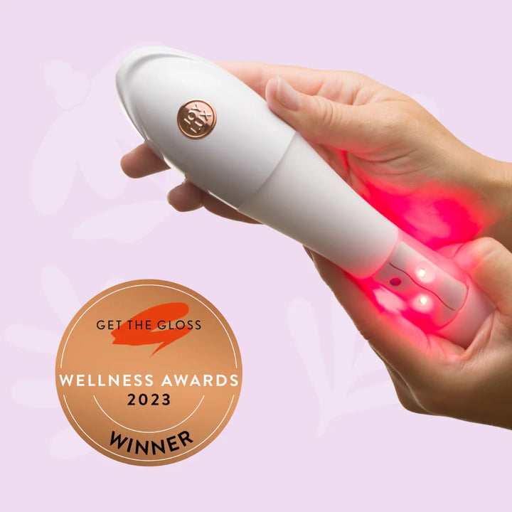 Female hands hold the Issviva x Joylux Rejuvenation device, showing its elegant and ergonomic design on a neutral background.