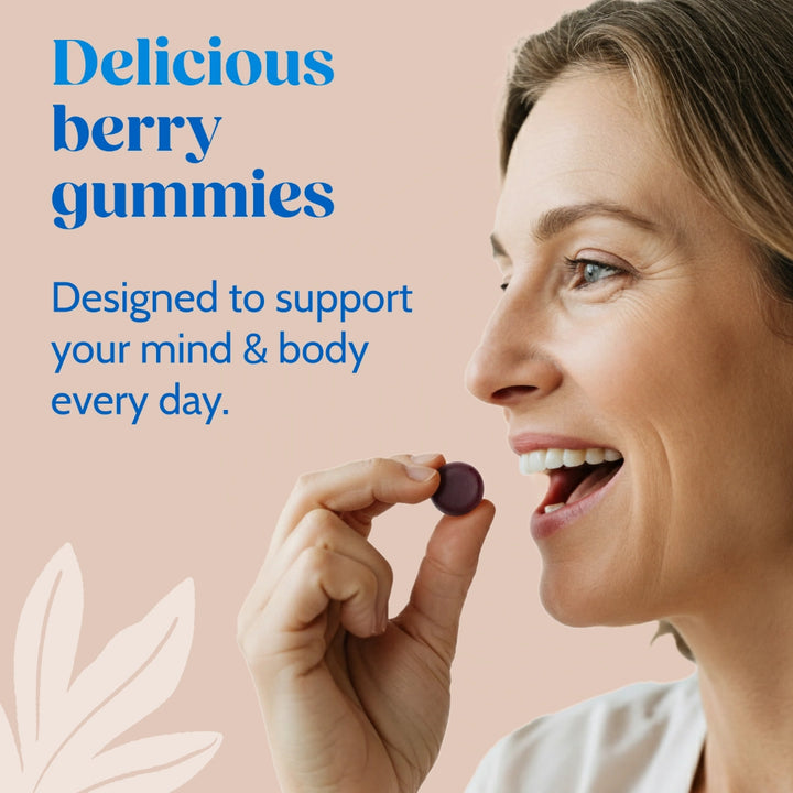 Woman holding a berry gummy with text about delicious berry gummies supporting mind and body on a pink background